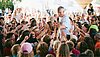 Bastian Campmann, der Sänger der Kölner Band Kasalla, steht mitten im Publikum beim VIVAWEST Family Festival im Kölner Tanzbrunnen. In einer Hand hält er ein Mikrophon, mit der anderen klatscht er Kinder im Publikum ab. Um ihn herum stehen viele Kinder, die ihre Hände in die Höhe gereckt halten, um auch abgeklatscht zu werden. 