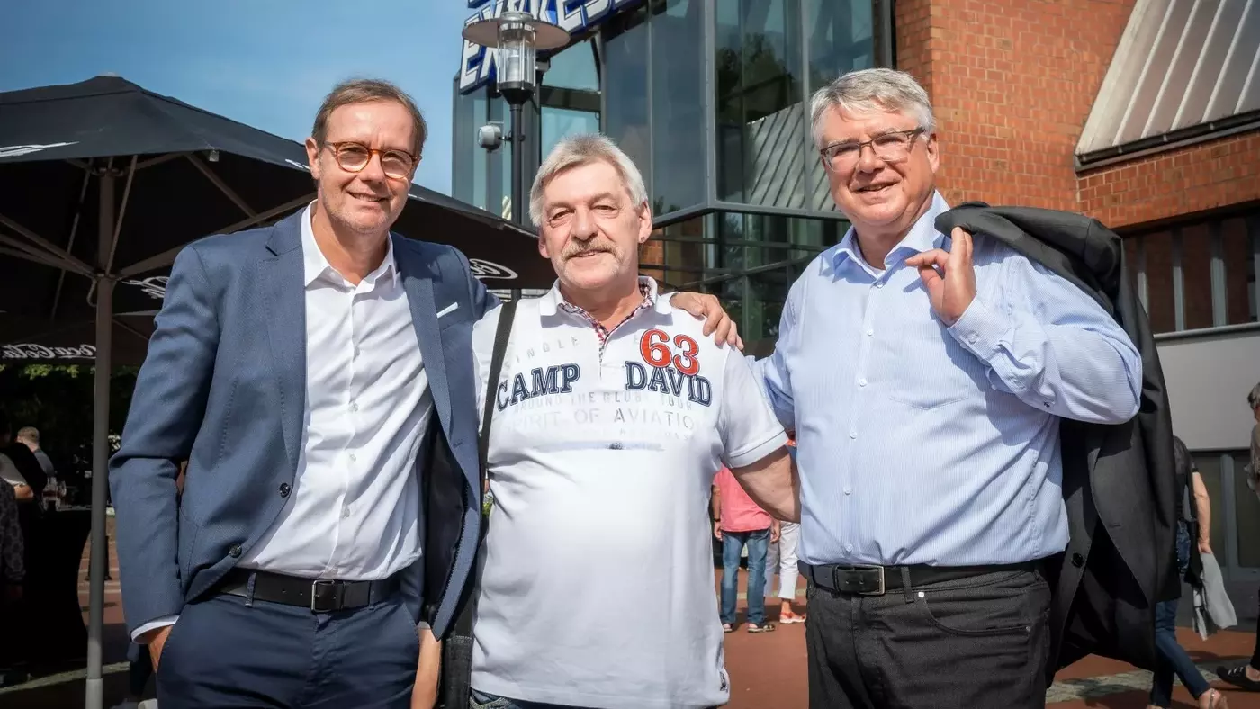 Die beiden Geschäftsführer der Vivawest Stiftung Dr. Stephan Schmidt (links im Bild) und Thomas Wels (rechts im Bild) stehen mit einem Ehrenamtlichen vor dem Starlight Express Theater in Bochum. 