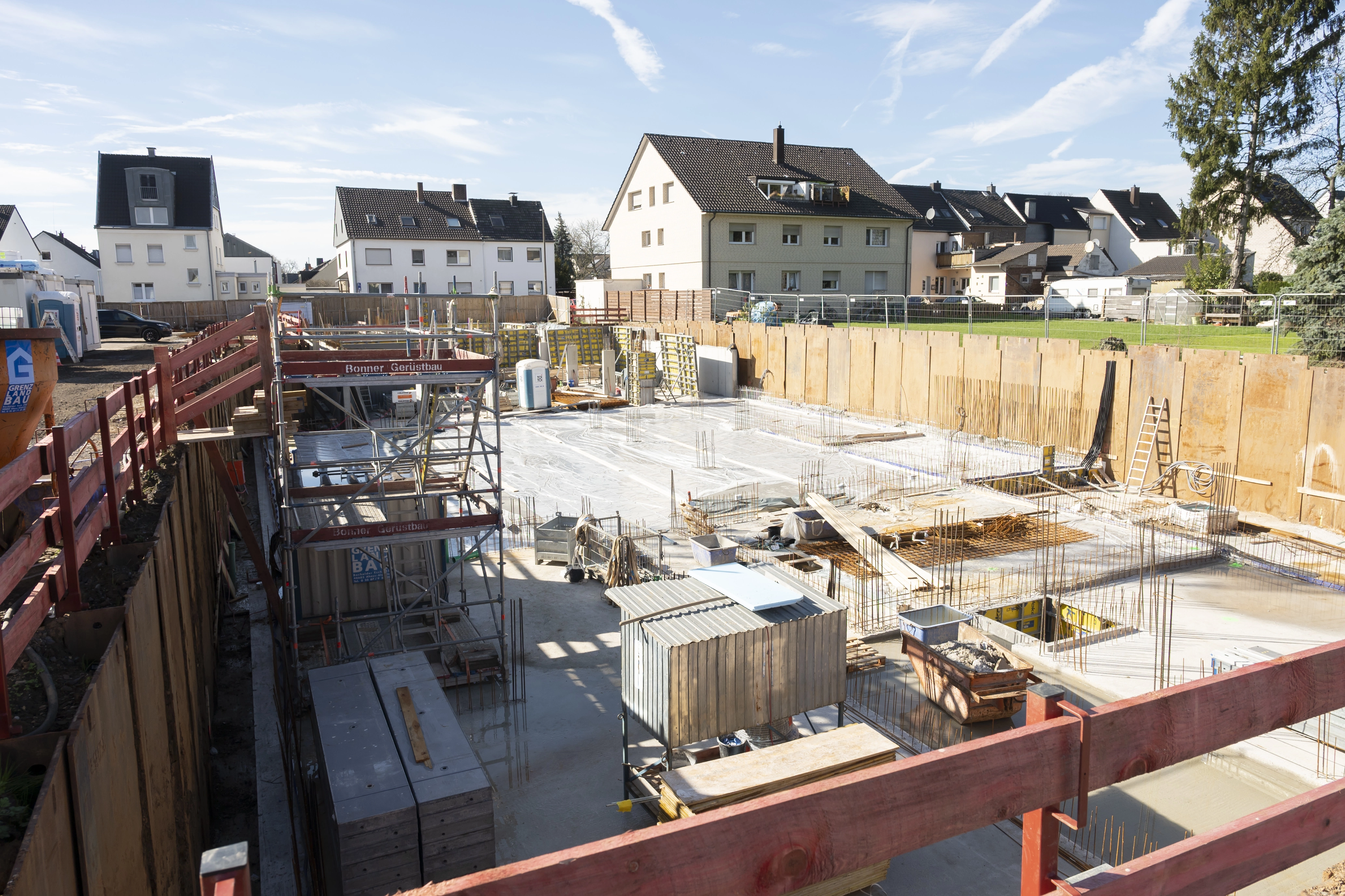 Zu sehen ist die Bodenplatte eines Hauses, dass gebaut werden soll. Darauf befinden sich allerlei Baumaterialien