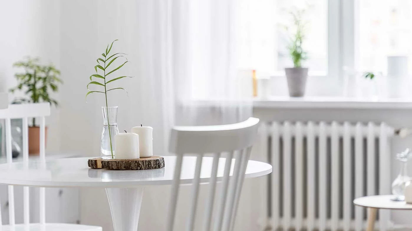 Blick in ein Wihnzimmer mit weißen Möbeln und weißen Vorhängen